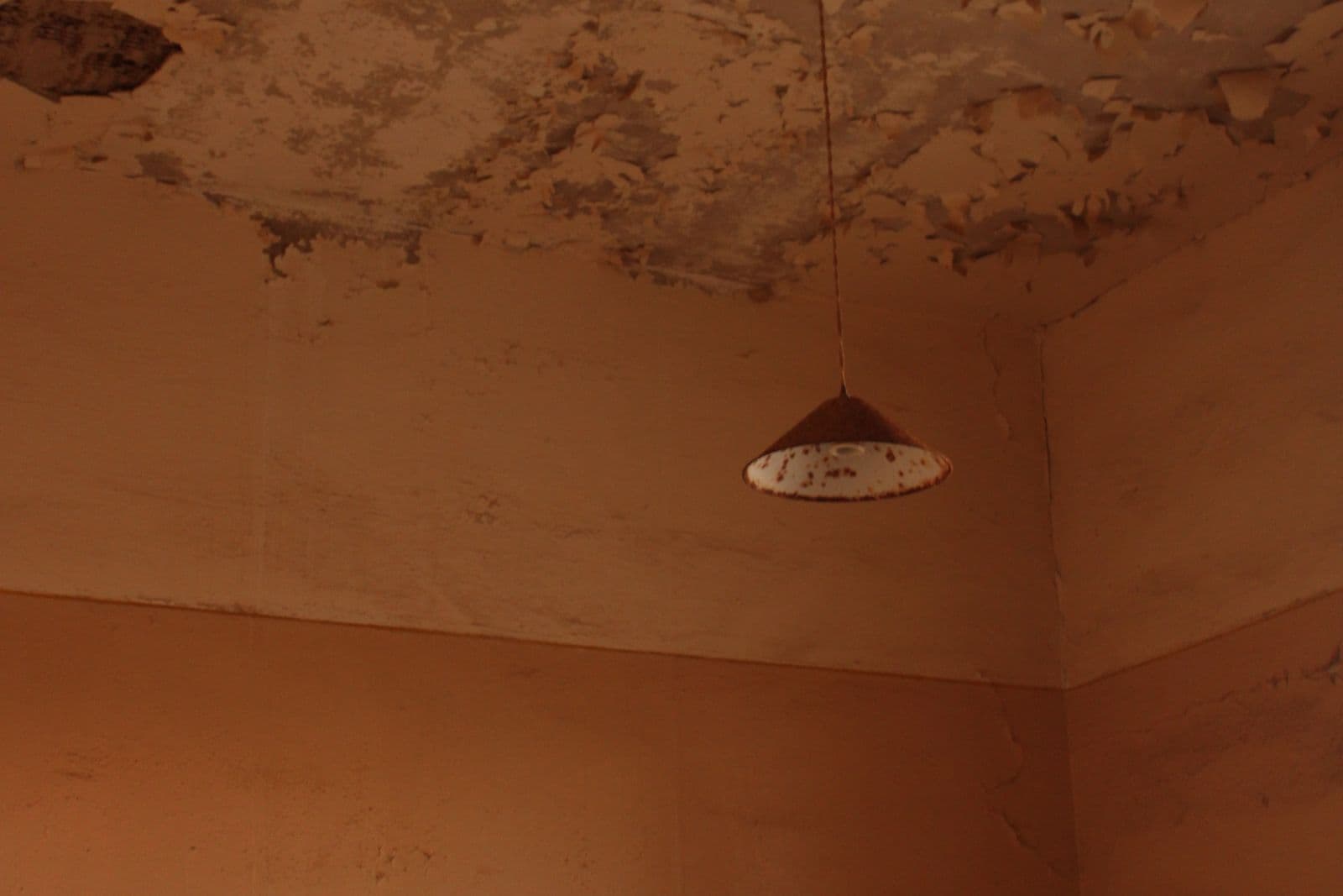 Before: Ceiling corner with peeling, water-stained drywall
