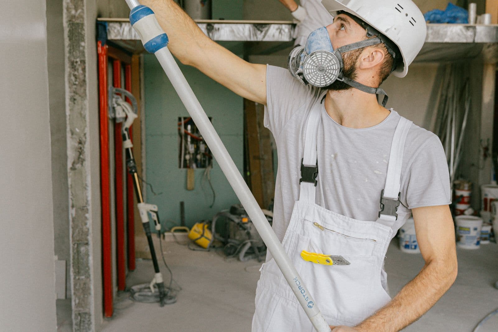 Restoration worker in a respirator renovating a room